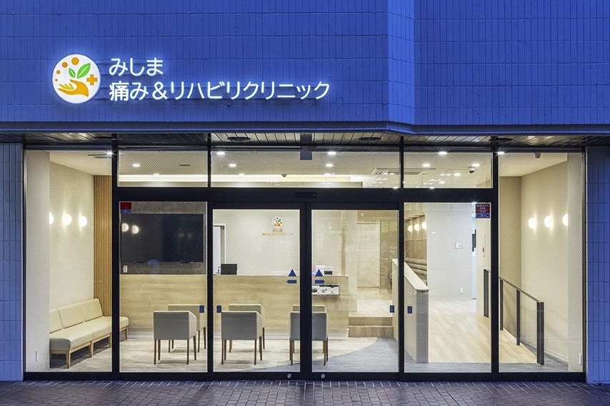 みしま痛み＆リハビリクリニックのガラス越しに待合が見えるファサード